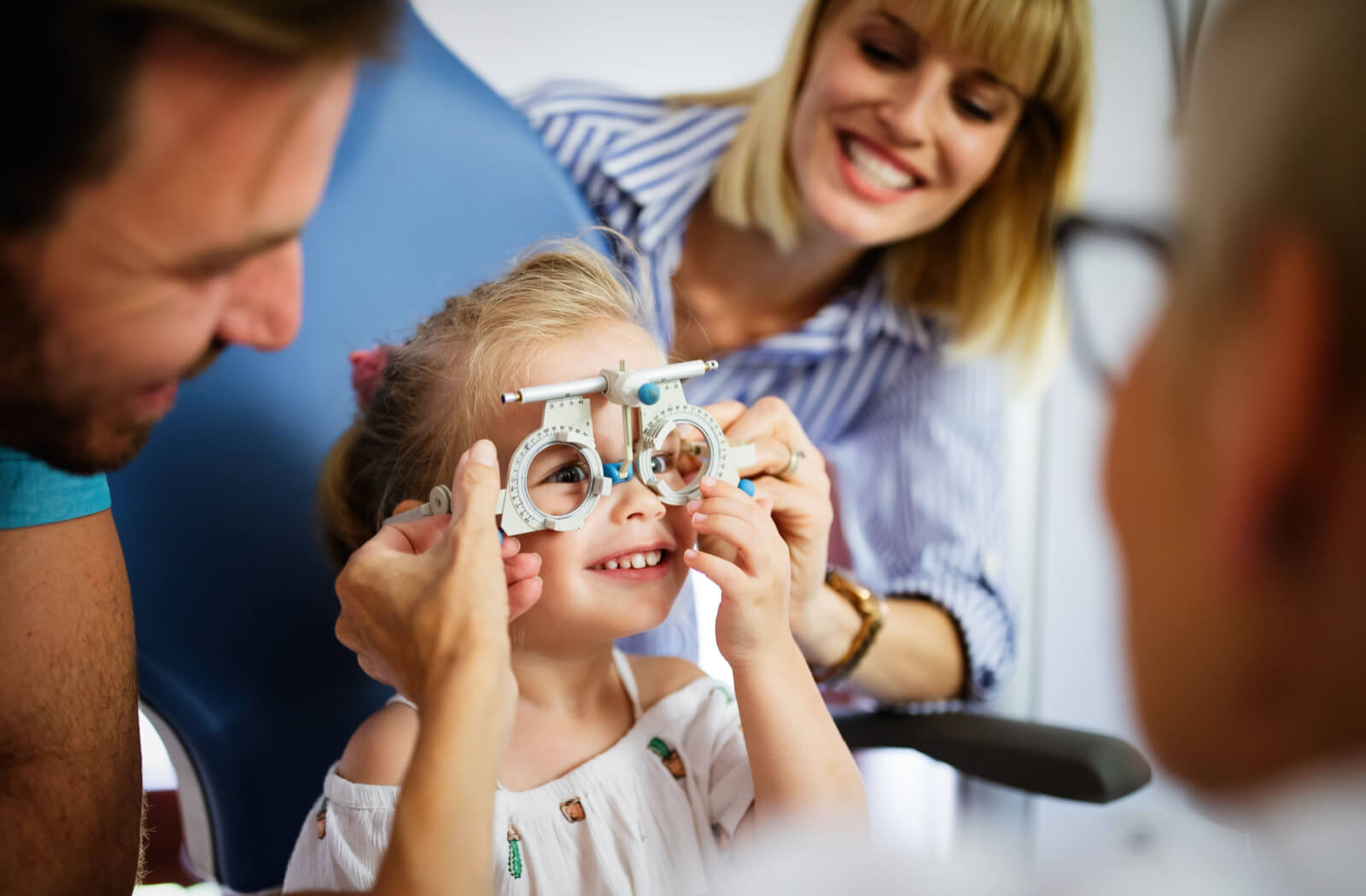 Parents and their kid have fun during their daughter first eye exam