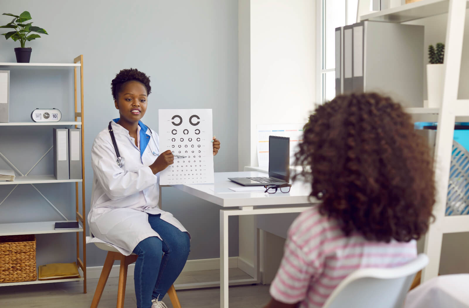 An eye doctor tests a child's eyesight with the Landolt C eye chart